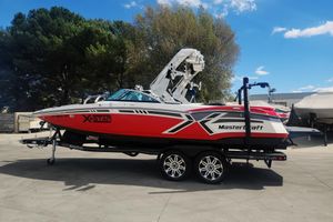 MasterCraft XStar 2013 MasterCraft XStar boat on trailer, red and white design, parked outdoors.
