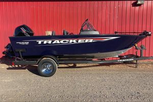 Tracker Pro Guide V-175 WT 2026 Tracker Pro Guide V-175 WT boat on trailer, parked by red wall.