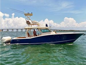 Scout 420 LXF 2018 Scout 420 LXF boat cruising on open water with bridge in background.
