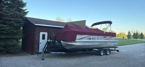 South Bay 622 Cr 2008 South Bay 622C pontoon boat with maroon cover, parked on a trailer beside a shed.