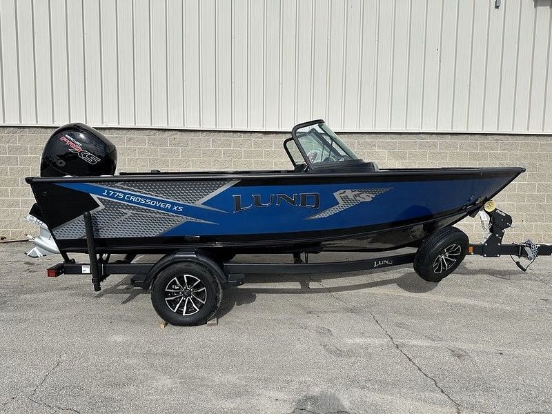 Lund 1775 Crossover XS 2021 Lund 1775 Crossover XS boat on trailer, blue and black design, parked outdoors.