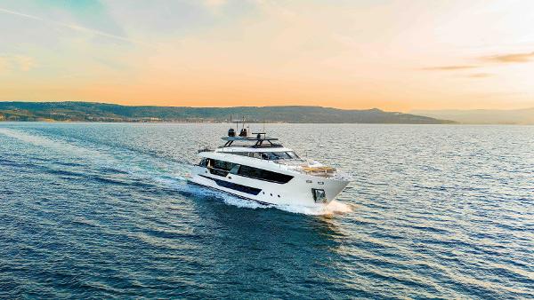 Ferretti Yachts 1000 2023 Ferretti Yachts 1000 cruising at sunset on open water.