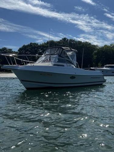 Aquasport 225 Explorer 2000 Aquasport 225 Explorer boat on calm water under a clear sky.