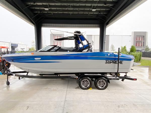Supreme S240 2023 Supreme S240 boat in a showroom, blue and white design, on a trailer.