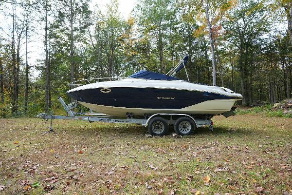 Stingray 225 CR 2016 Stingray 225 CR boat on trailer in wooded area.