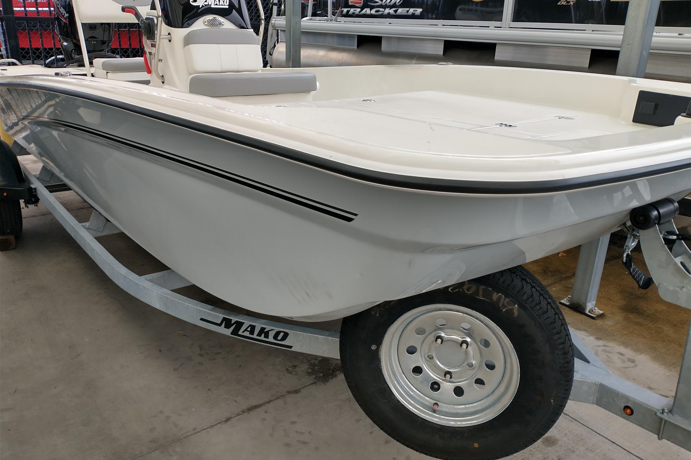 Mako Pro Skiff 17 CC 2026 Mako Pro Skiff 17 CC boat on trailer, displayed indoors.