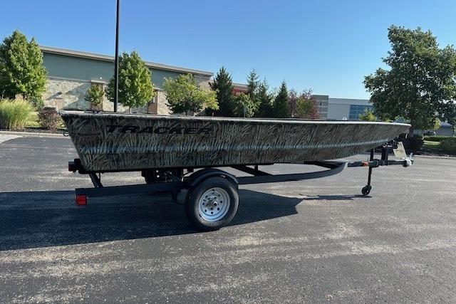 Tracker Grizzly 1648 Utility 2026 Tracker Grizzly 1648 Utility boat on trailer in parking lot.