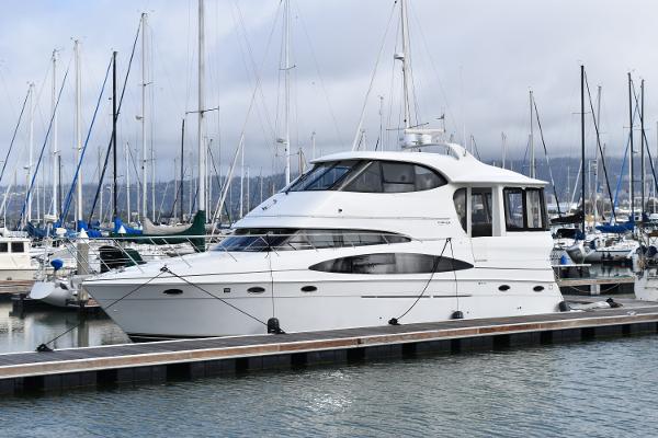 Carver 506 Motor Yacht 2000 Carver 506 Motor Yacht docked in a marina with sailboats in the background.