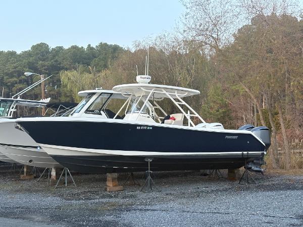 Pursuit C 280 Center Console 2014 Pursuit C 280 Center Console boat on stands, surrounded by trees.