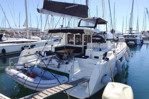 Lagoon 40 2020 Lagoon 40 catamaran docked in a marina, featuring a spacious deck and inflatable dinghy.