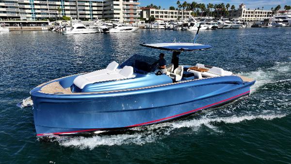 Solaris Power Open Co Ownership 2023 Solaris Power 40 Open yacht cruising in a marina with modern buildings in the background.