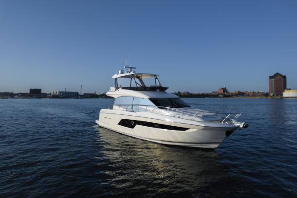 Prestige 520 2023 Prestige 520 F-Line yacht cruising on calm waters under a clear blue sky.