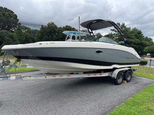 NauticStar 243 DC 2023 NauticStar 243 DC boat on trailer, parked outdoors under cloudy sky.