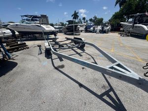 Trailer KARAVAN 17-21 Boat trailer KARAVAN 17-21, 2019 model, in a marina with boats and palm trees.
