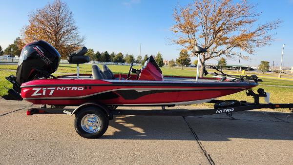 Nitro Z17 2024 Nitro Z17 fishing boat on trailer, red and black design, parked outdoors.