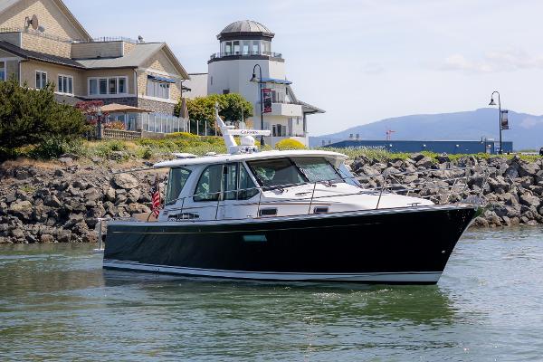 Sabre 43 Salon Express 2023 Sabre 43 Salon Express yacht cruising near waterfront homes and lighthouse.