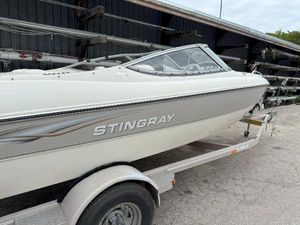 Stingray 200 Lx 2003 Stingray 200LX boat on trailer, parked outdoors near storage facility.
