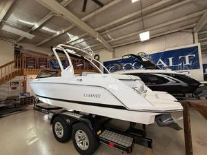Cobalt CS22 2025 Cobalt CS22 boat on trailer in showroom, featuring sleek white design.