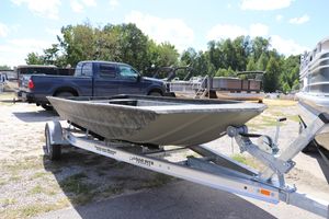 Tracker Grizzly 1860 Utility 2025 Tracker Grizzly 1860 Utility boat on trailer, parked outdoors near trucks and other boats.