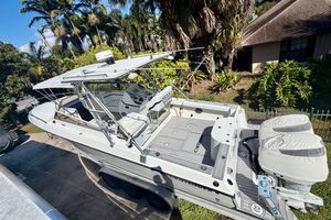 Contender 35 Side Console 2002 Contender 35 Side Console boat with dual engines, parked near tropical foliage.