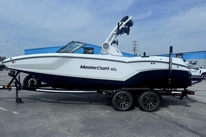 MasterCraft NXT22 2026 MasterCraft NXT22 boat on trailer, parked outdoors, side view.