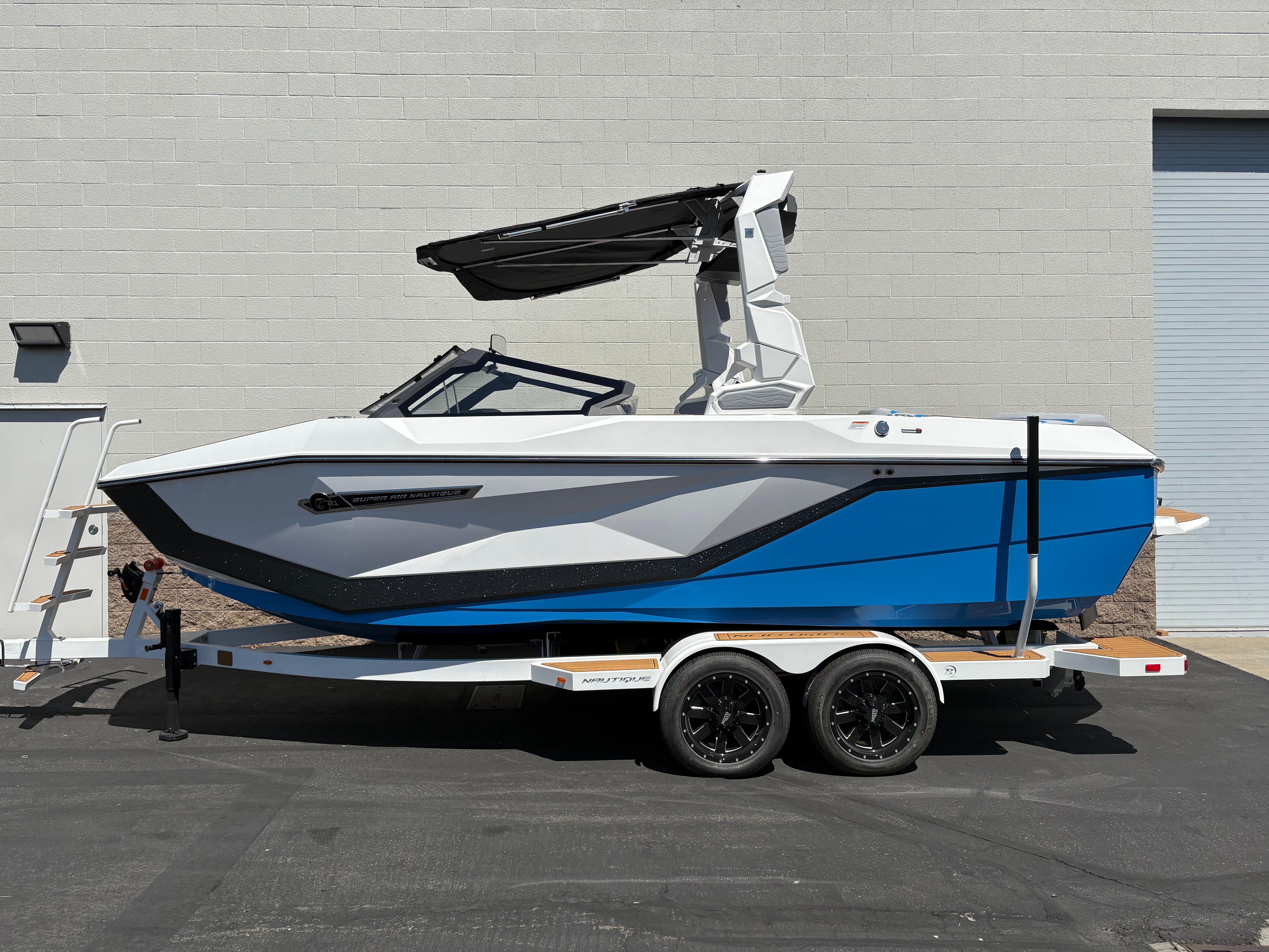 Nautique Super Air Nautique G21 2026 Nautique Super Air Nautique G21 boat on trailer, blue and white design, parked outdoors.