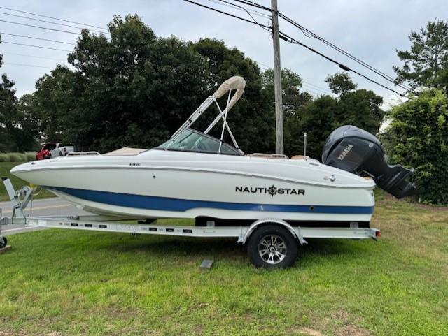NauticStar 203 DC Deck 2025 NauticStar 203 DC Deck boat on trailer, parked on grass.