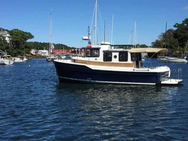 Ranger Tugs R-29 2012 Ranger Tugs R-29 boat docked in a scenic marina with clear blue skies.