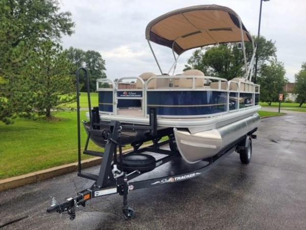 Sun Tracker Bass Buggy 18 DLX 2025 Sun Tracker Bass Buggy 18 DLX pontoon boat on trailer, parked outdoors.