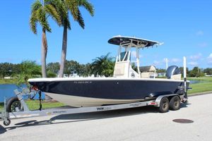 Pathfinder 2500 Hybrid 2017 Pathfinder 2500 Hybrid boat on trailer, parked near palm trees and water.