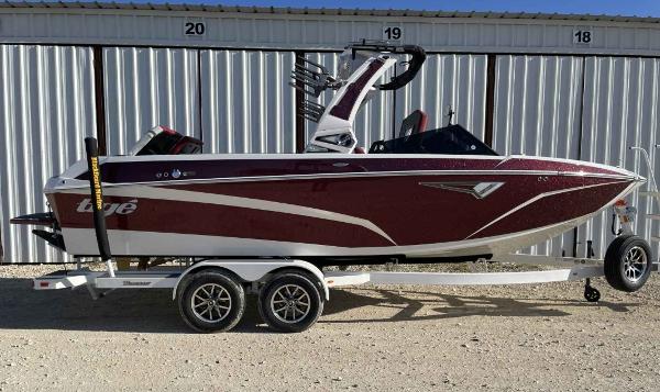 Tigé Z3 2024 Tigé Z3 boat on trailer, maroon and white, parked outdoors.