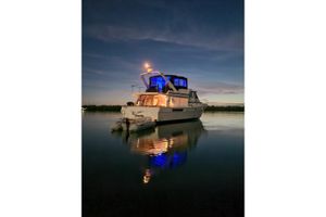 Bayliner 4550 Motoryacht 1987 Bayliner 4550 Motoryacht illuminated at dusk on calm water.