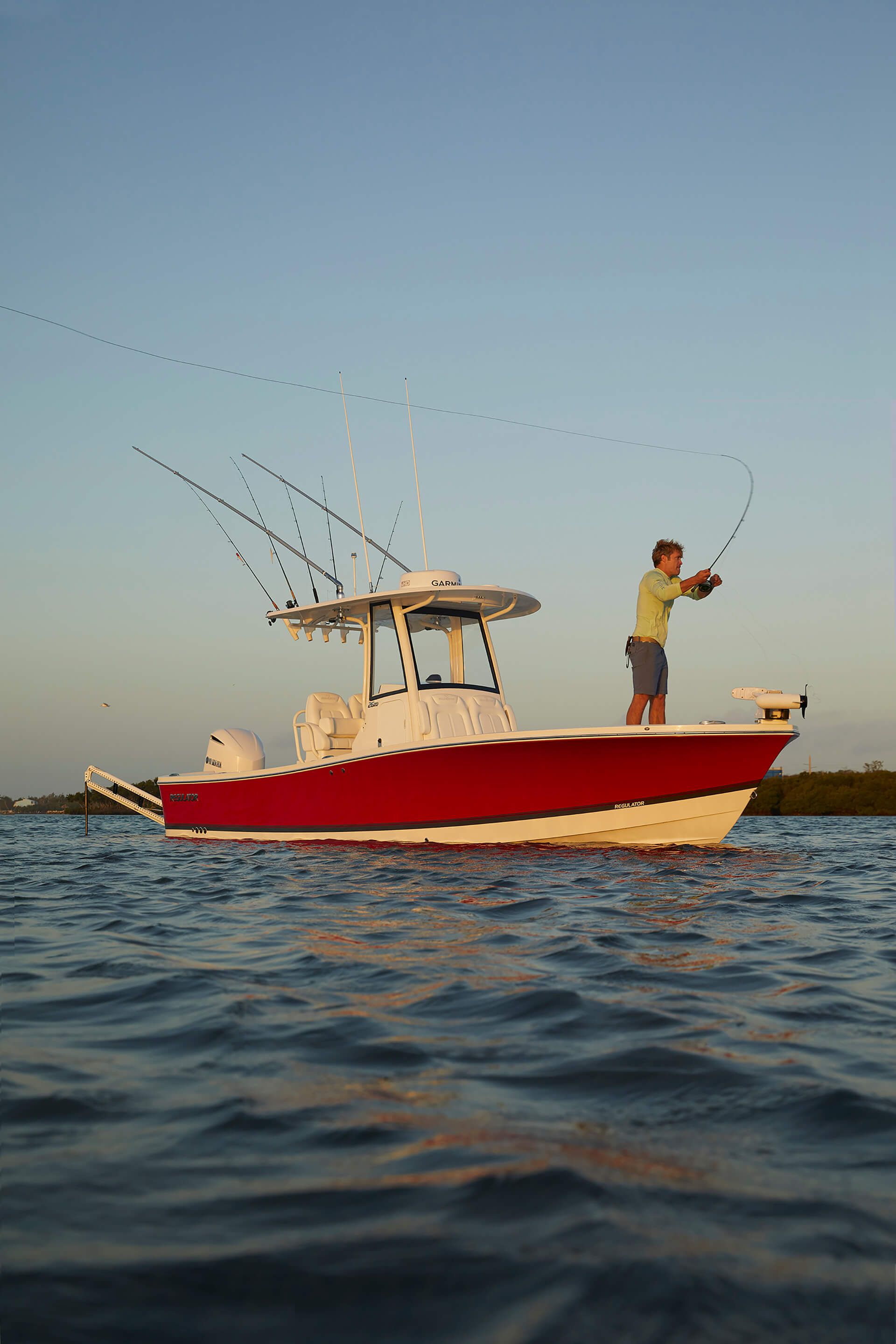 Regulator 26XO Man fishing on a 2026 Regulator 26XO boat in calm waters at sunset.