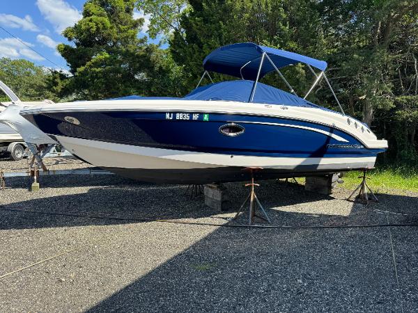 Chaparral 246 SSi 2014 Chaparral 246 SSi boat with blue hull and canopy, parked on stands.