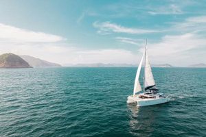Lagoon 450F Sailing catamaran Lagoon 450F 2017 on open sea with scenic coastal backdrop.