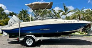 Stingray 191 DC 2021 Stingray 191 DC boat on trailer with canopy, Suzuki outboard motor, and palm trees in background.