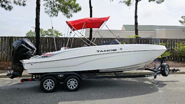 Tahoe T21 2025 Tahoe T21 boat with red canopy on trailer, parked outdoors.