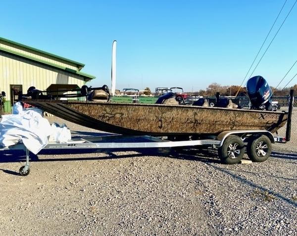 Xpress XP200 2024 Xpress XP200 boat on trailer, parked outdoors near a building.