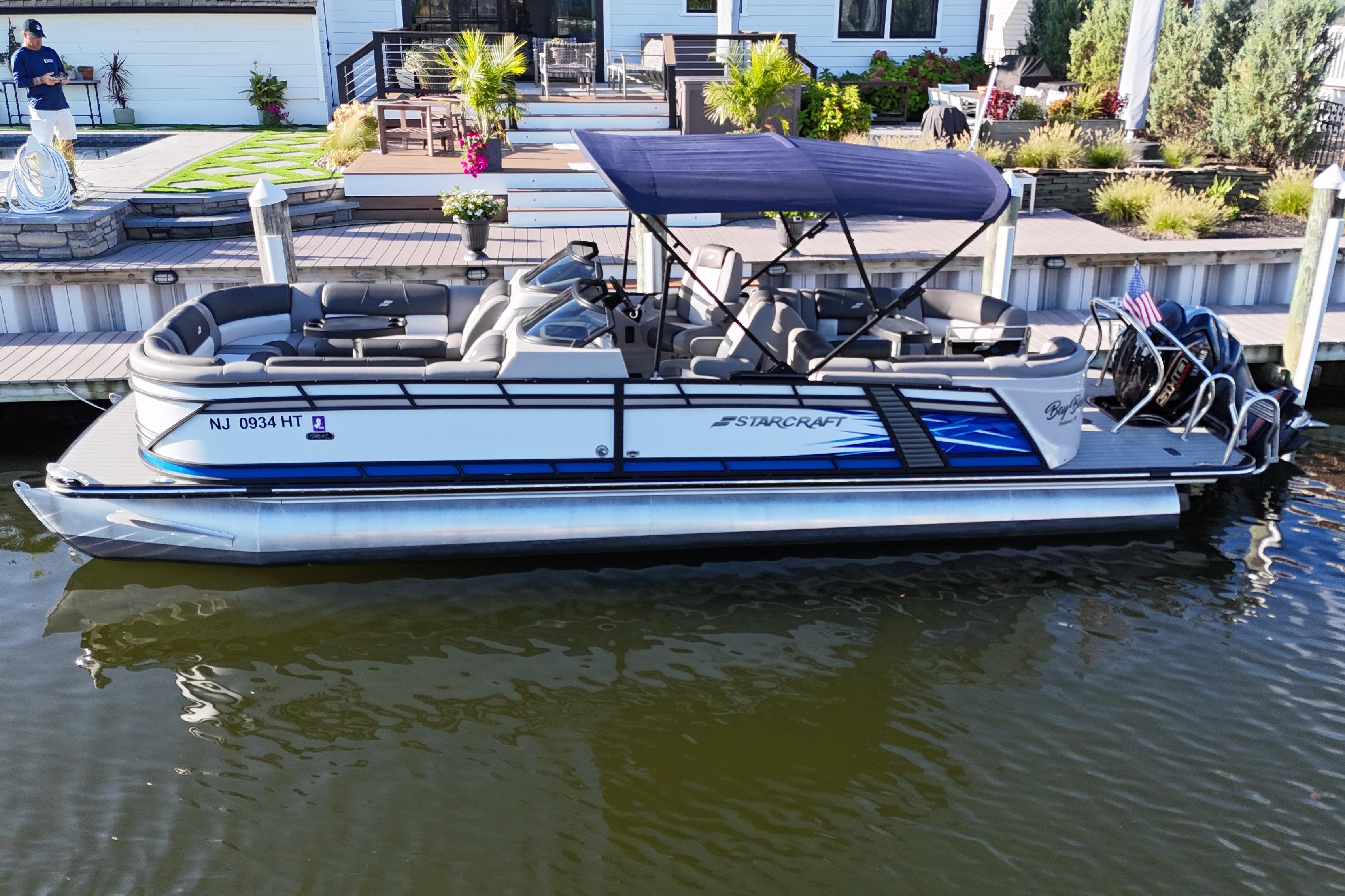 Starcraft MX 25 R DC 2023 Starcraft MX 25 R DC pontoon boat docked by a waterfront home.