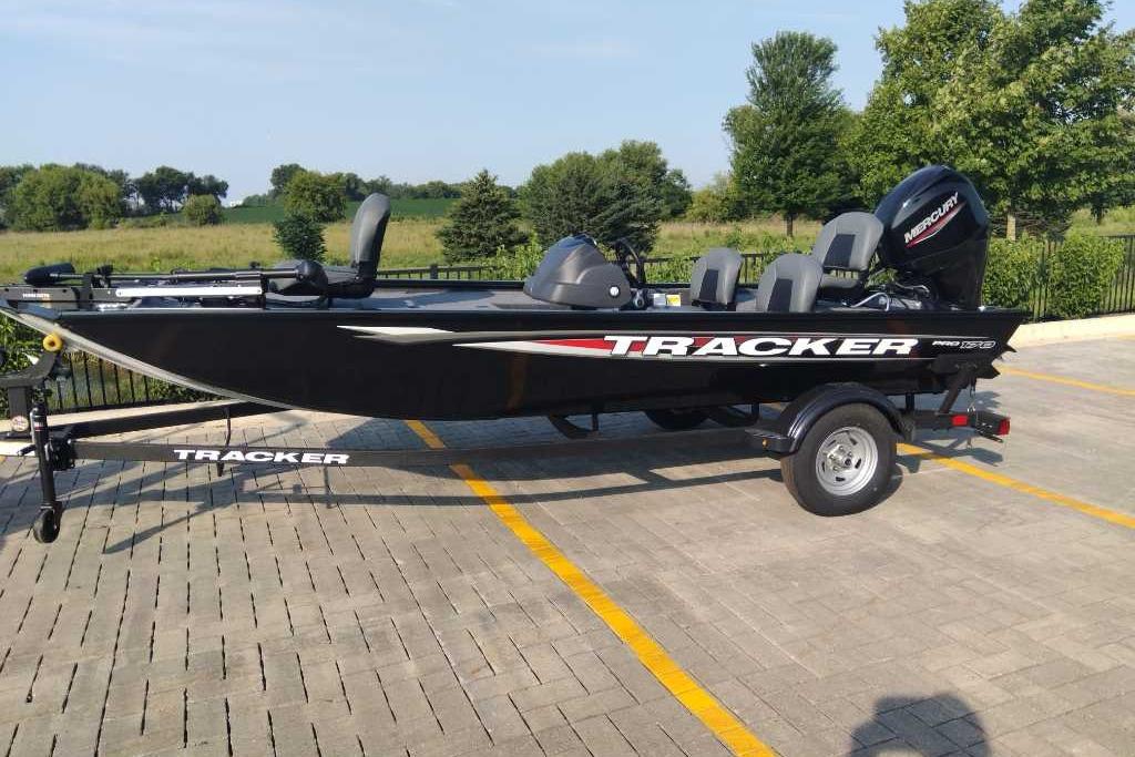 Tracker Pro 170 2026 Tracker Pro 170 boat on trailer in parking lot, surrounded by greenery.
