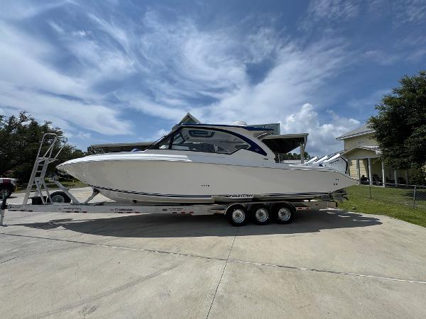 Fountain 39 DX 2026 Fountain 39 DX boat on trailer, parked outdoors under a partly cloudy sky.