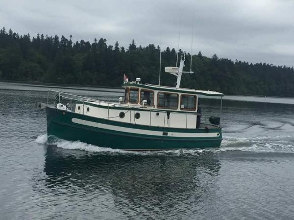 Nordic Tug 26 Sport 1982 Nordic Tug 26 Sport cruising on a calm lake with forested shoreline.