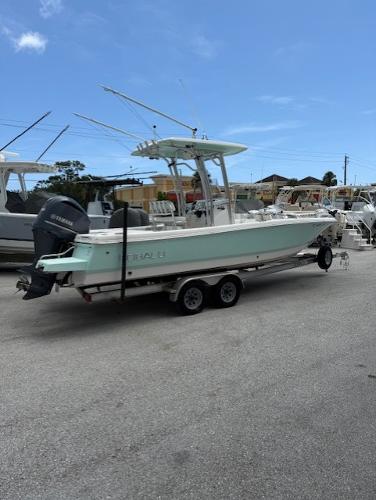 Robalo 246 Cayman 2018 Robalo 246 Cayman boat on trailer, parked outdoors under clear blue sky.