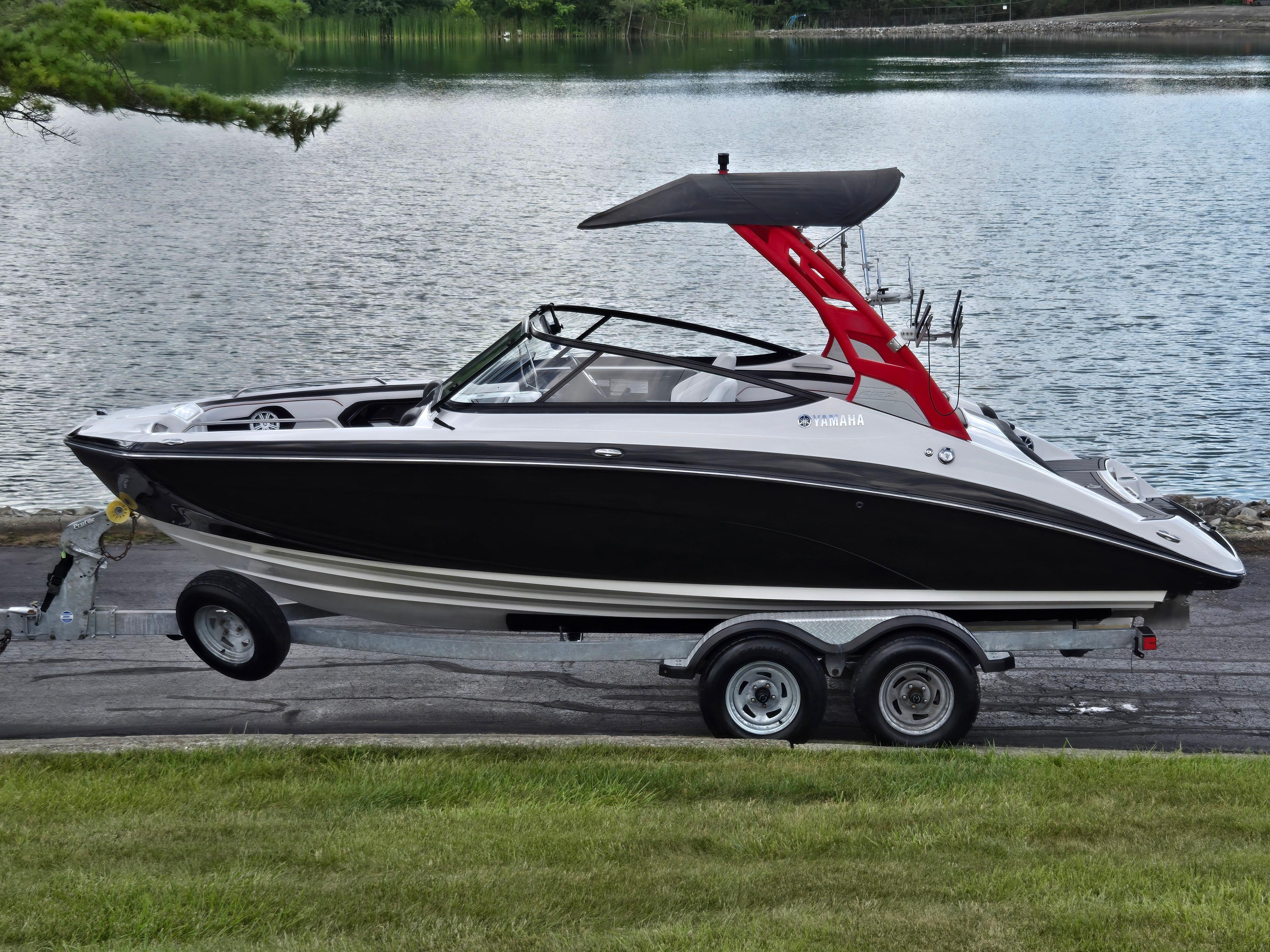 Yamaha Boats 212X 2018 Yamaha Boats 212X on trailer by a serene lake.