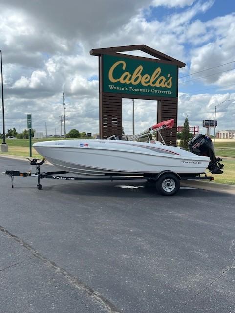 Tahoe T18 2023 Tahoe T18 boat on trailer outside Cabela's store, under cloudy sky.