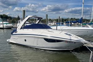 Regal 28 Express 2023 Regal 28 Express boat docked in a marina under a partly cloudy sky.