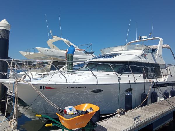 Ocean Alexander 42 1989 Ocean Alexander 42 yacht docked, with a person cleaning the deck under clear blue skies.