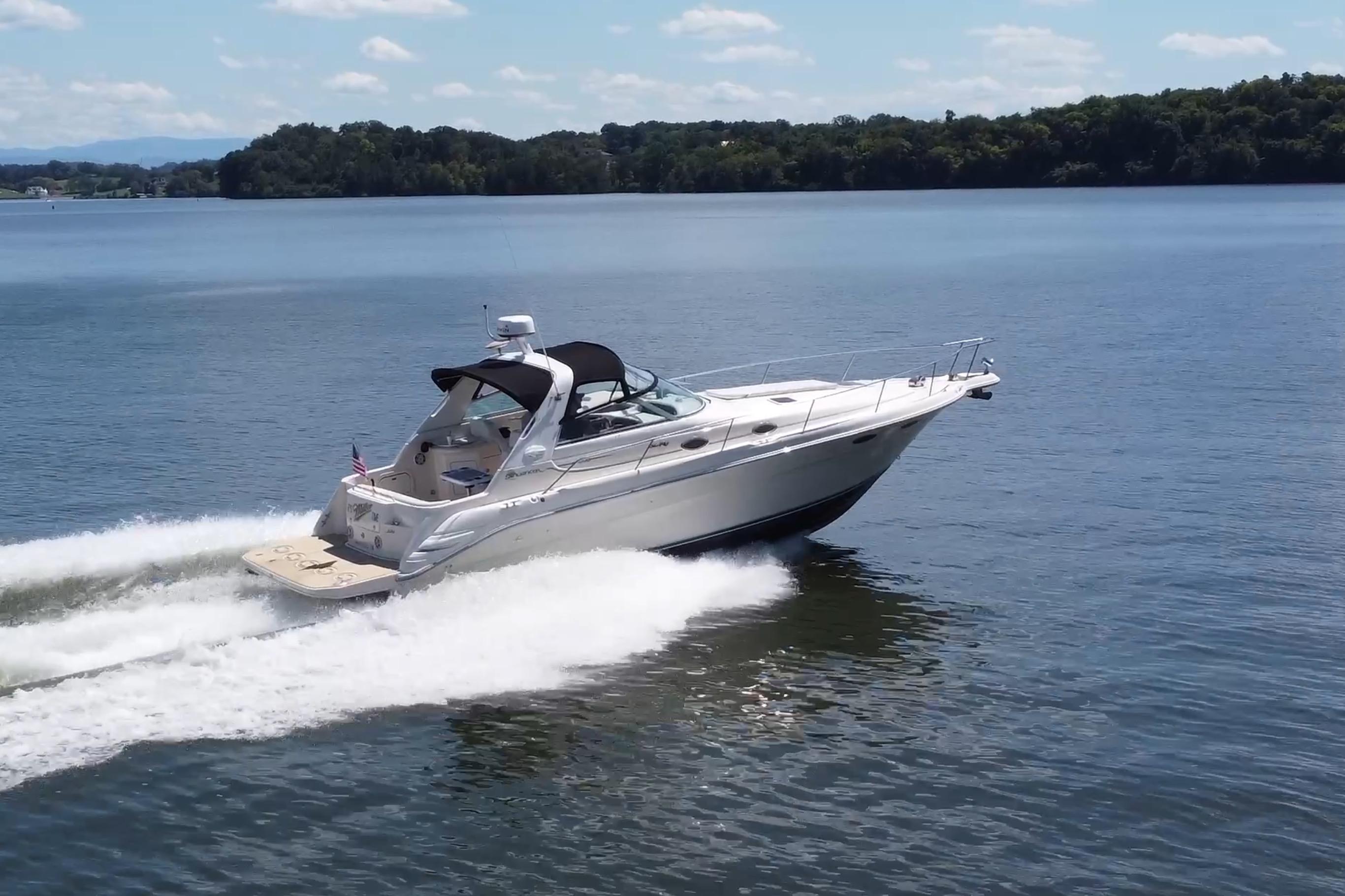 Sea Ray 330 Sundancer 1995 Sea Ray 330 Sundancer cruising on a serene lake under a clear sky.