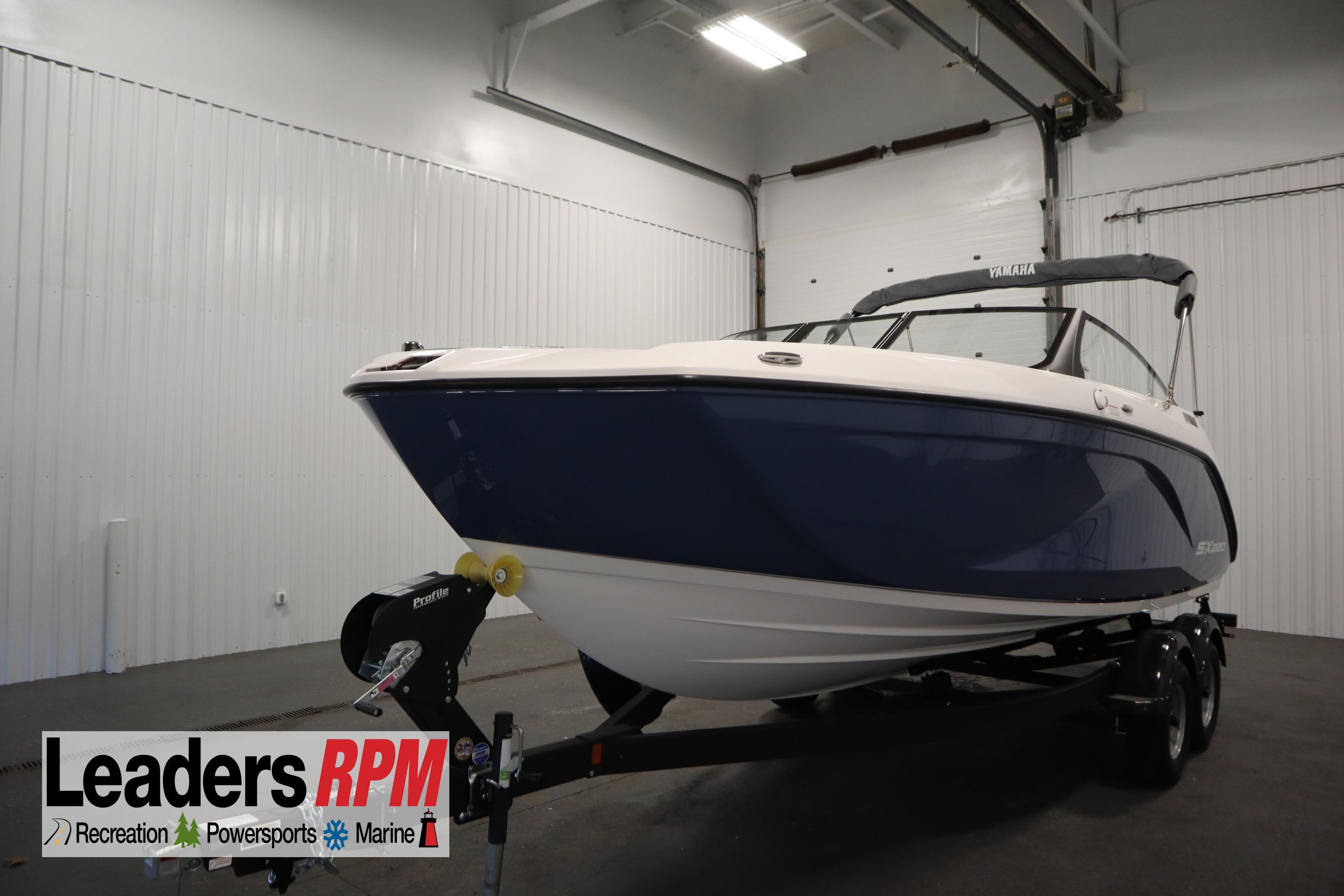 Yamaha Boats SX220 2026 Yamaha Boats SX220 in showroom, blue and white design, on trailer.