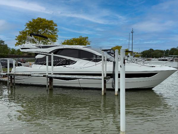 Galeon 560 Sky 2018 Galeon 560 Sky yacht docked on a calm lake under a blue sky.